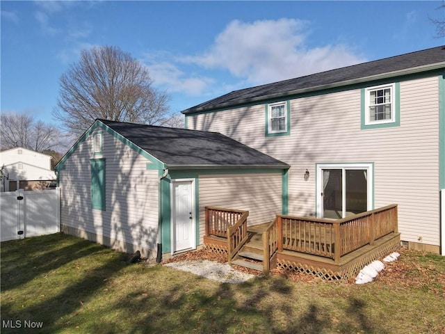 back of house featuring a wooden deck and a yard