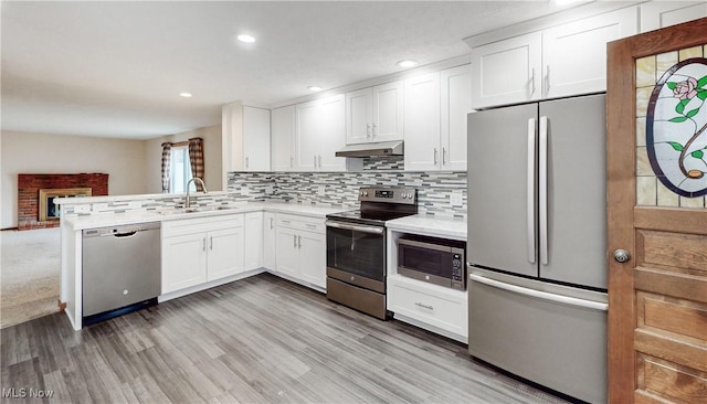 kitchen featuring sink, backsplash, white cabinets, and appliances with stainless steel finishes