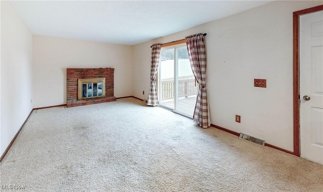 unfurnished living room with a brick fireplace and carpet