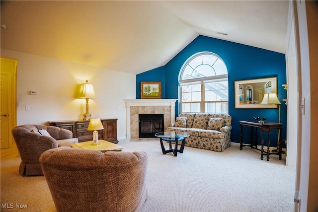 living room with light colored carpet, lofted ceiling, and a tile fireplace