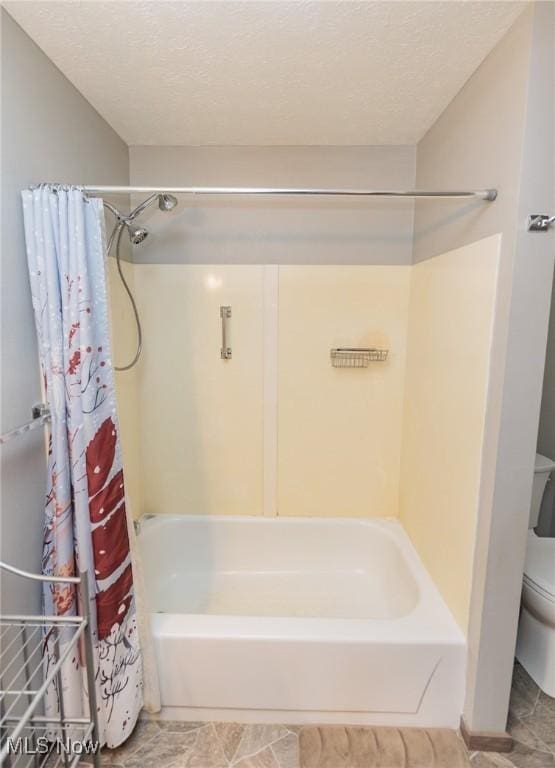 bathroom with shower / bathtub combination with curtain, toilet, and a textured ceiling