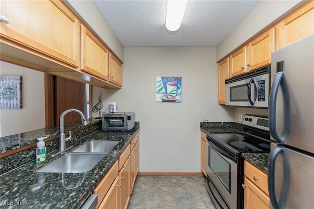 kitchen featuring appliances with stainless steel finishes, sink, and dark stone counters