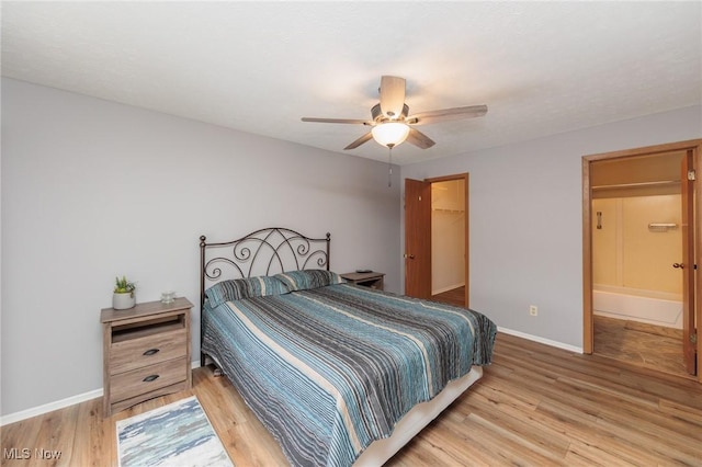 bedroom with a walk in closet, wood-type flooring, a closet, and ceiling fan