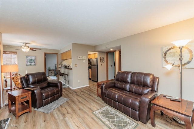 living room with ceiling fan and light wood-type flooring