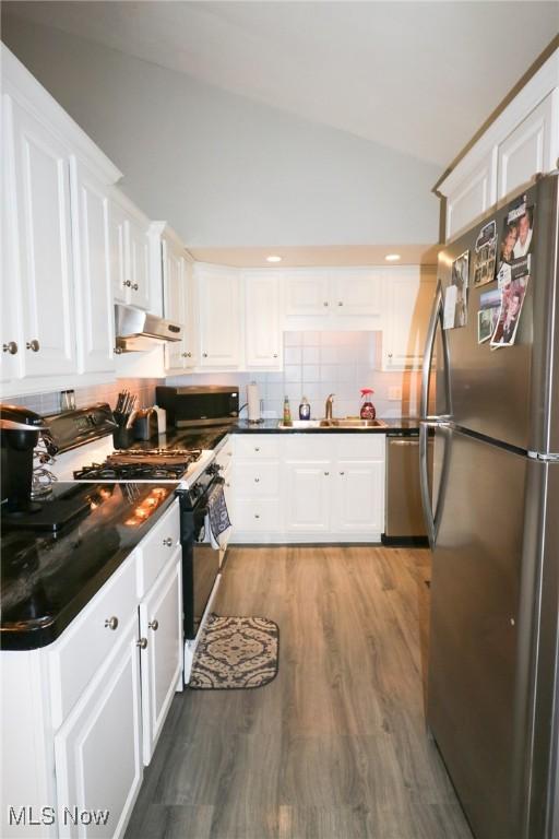 kitchen featuring sink, appliances with stainless steel finishes, tasteful backsplash, wood-type flooring, and white cabinets