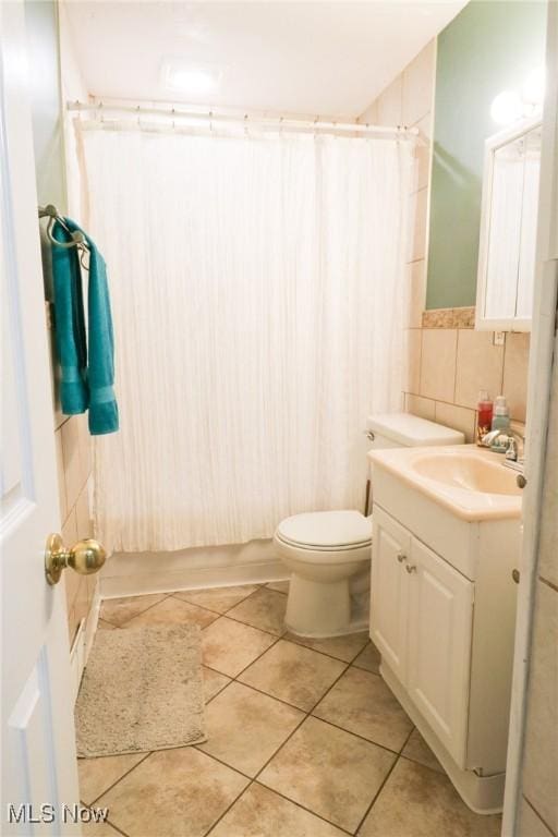 full bathroom featuring tile patterned floors, toilet, tile walls, and vanity