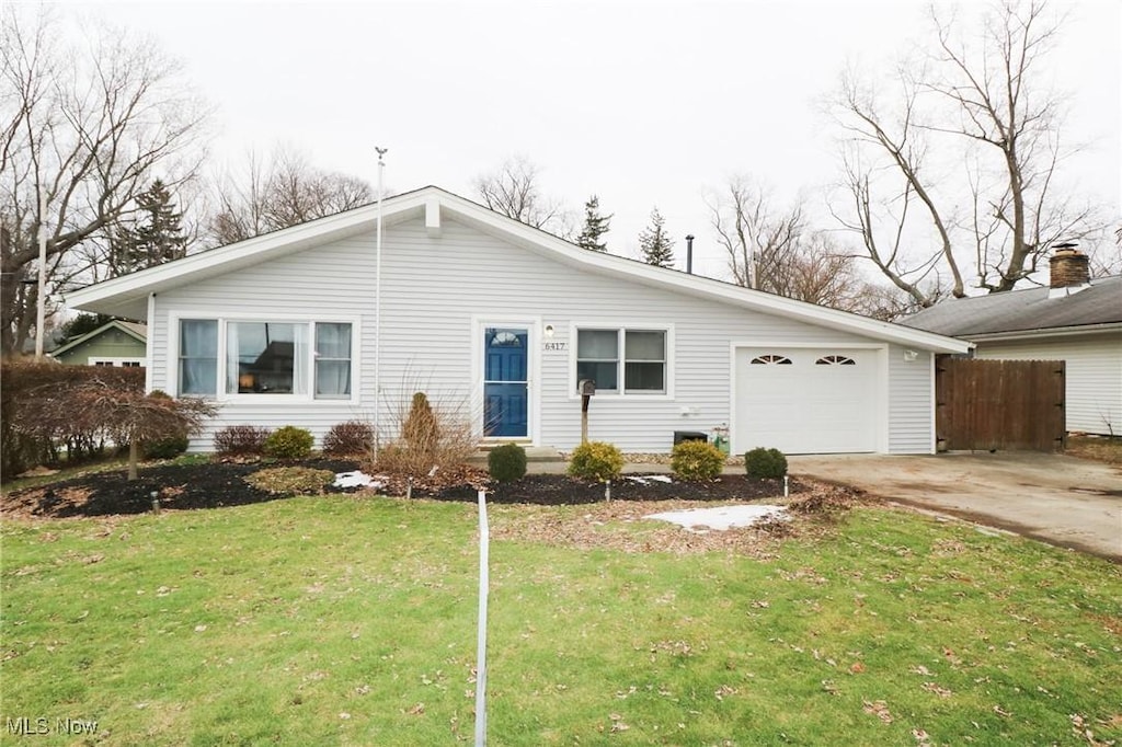 single story home with a garage and a front lawn