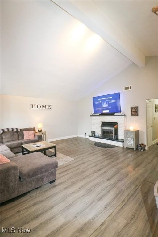 living room with hardwood / wood-style floors, a fireplace, and lofted ceiling with beams