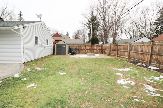 view of yard with a shed and an outdoor fire pit