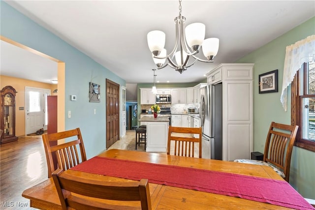 dining room with a notable chandelier and light hardwood / wood-style floors