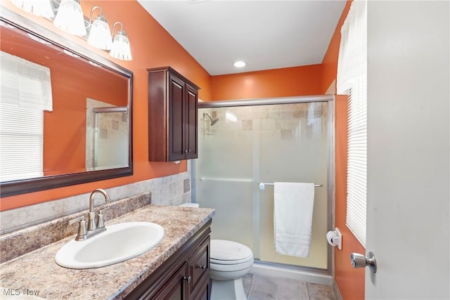 bathroom featuring vanity, an enclosed shower, tile patterned floors, and toilet