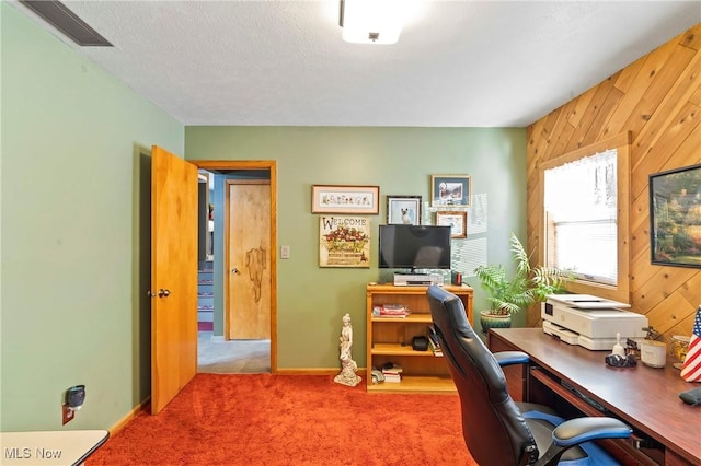 office with carpet floors, a textured ceiling, and wood walls