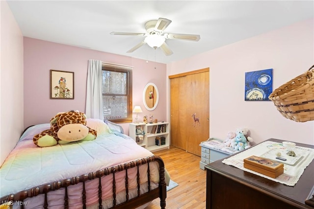 bedroom with ceiling fan, light hardwood / wood-style floors, and a closet