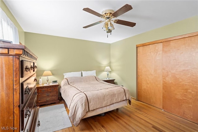 bedroom featuring ceiling fan, light wood-type flooring, and a closet