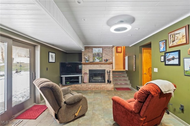 living room with a brick fireplace and ornamental molding