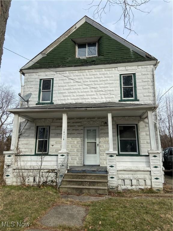 view of front of home with a porch and a front lawn