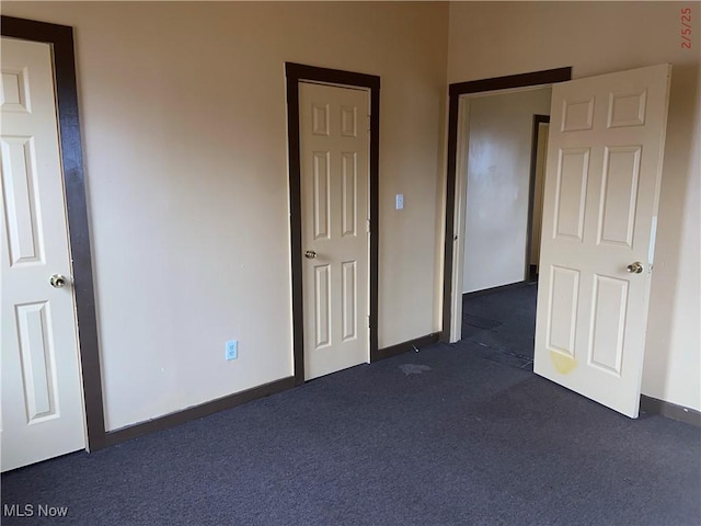 unfurnished bedroom featuring dark colored carpet