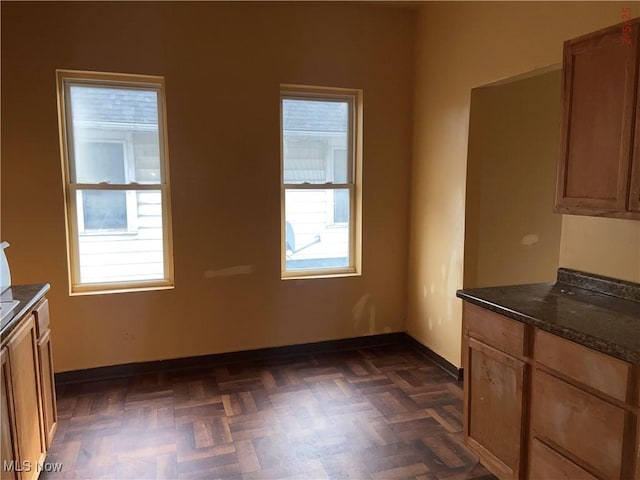 kitchen with dark parquet floors and dark stone countertops