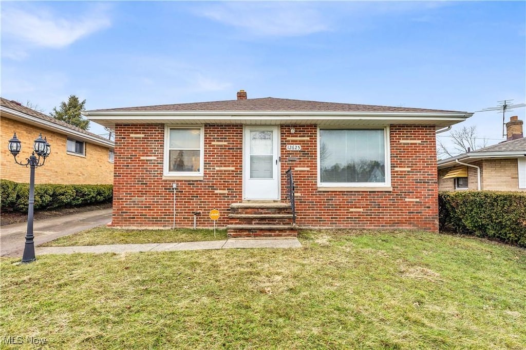 bungalow-style home featuring a front lawn