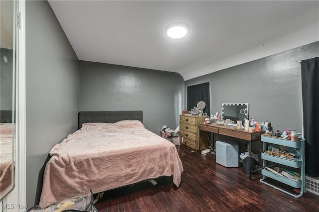 bedroom with lofted ceiling and dark hardwood / wood-style flooring