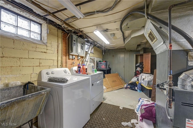 washroom with sink, electric panel, and washing machine and clothes dryer