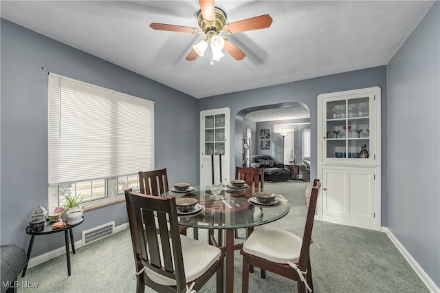 carpeted dining room featuring ceiling fan