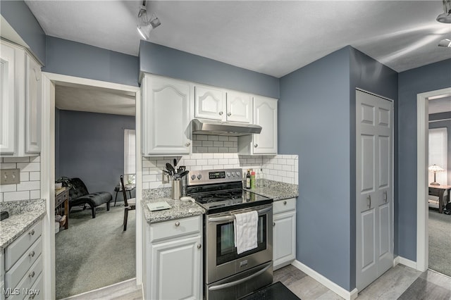 kitchen with electric stove, white cabinetry, tasteful backsplash, and light stone counters