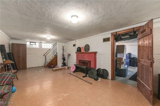 basement with a brick fireplace and a textured ceiling