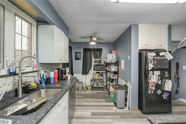 kitchen featuring black refrigerator, stainless steel dishwasher, light hardwood / wood-style floors, and white cabinets