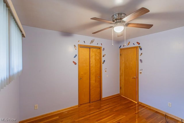 unfurnished bedroom with hardwood / wood-style floors, ceiling fan, and a closet