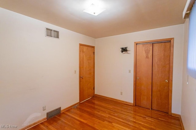 unfurnished bedroom featuring a closet and light wood-type flooring