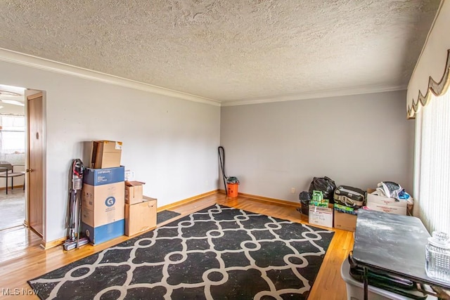 miscellaneous room featuring crown molding, wood-type flooring, and a textured ceiling