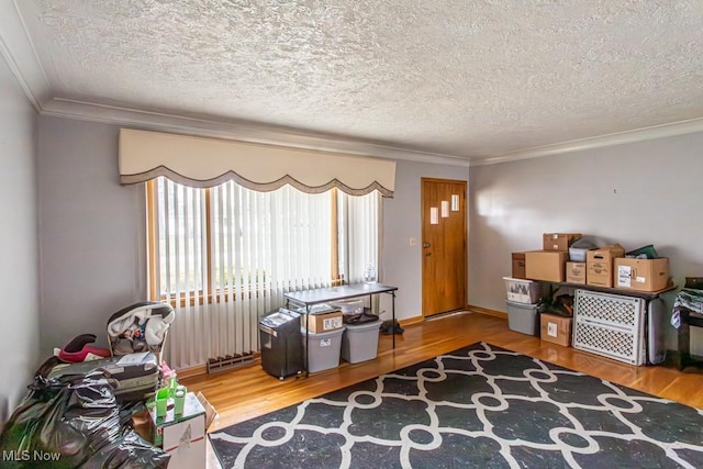 misc room featuring hardwood / wood-style flooring, crown molding, and a textured ceiling