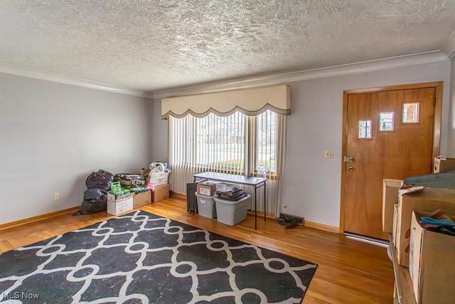 misc room featuring hardwood / wood-style flooring, ornamental molding, and a textured ceiling