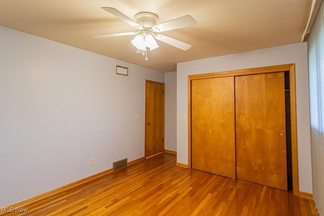 unfurnished bedroom with ceiling fan, a closet, and light wood-type flooring