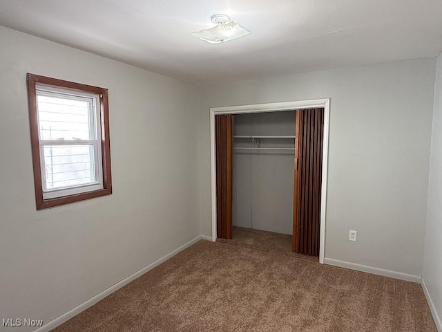 unfurnished bedroom featuring carpet and a closet