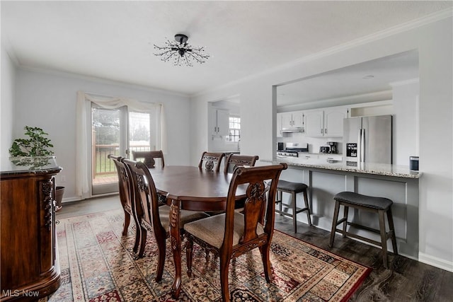 dining space with dark wood-type flooring and ornamental molding