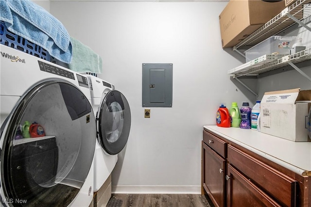 washroom with dark hardwood / wood-style flooring, electric panel, and washing machine and dryer