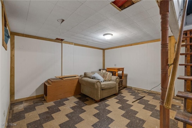 finished below grade area featuring stairs, baseboards, and tile patterned floors