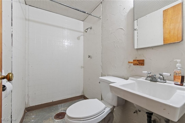 bathroom featuring concrete flooring, a sink, and toilet