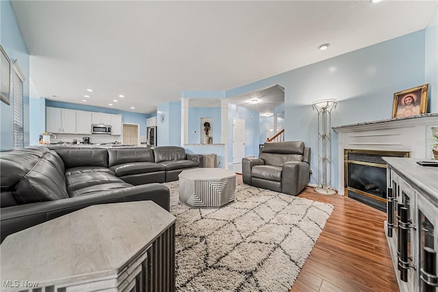 living room with light hardwood / wood-style flooring and ornate columns