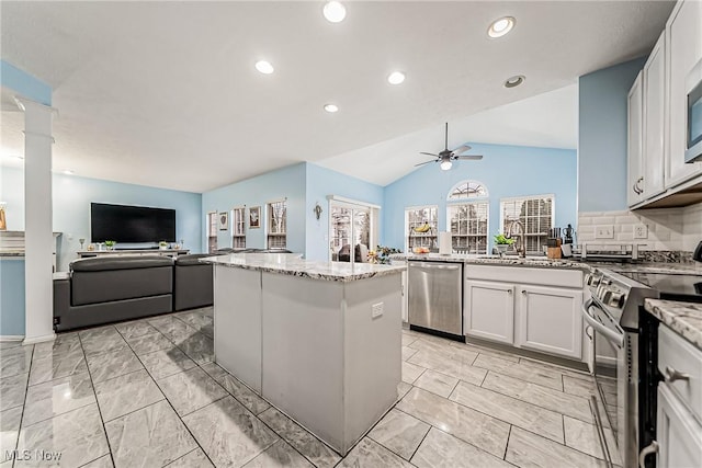 kitchen with a kitchen island, white cabinetry, lofted ceiling, ceiling fan, and stainless steel appliances