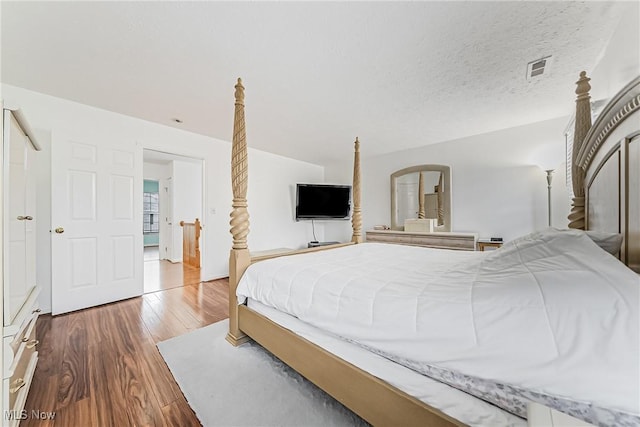 bedroom with hardwood / wood-style flooring and a textured ceiling