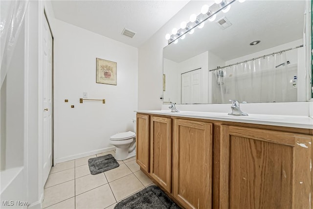 bathroom featuring vanity, tile patterned floors, and toilet