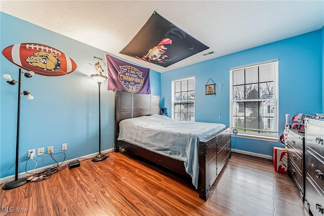 bedroom with wood-type flooring and a textured ceiling