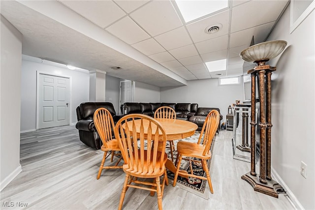 dining room featuring a paneled ceiling and light wood-type flooring