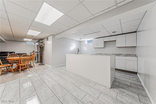 kitchen featuring white cabinetry and a drop ceiling