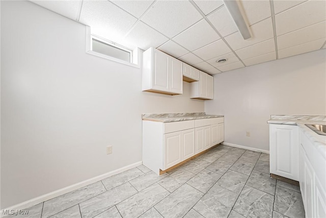 kitchen with white cabinetry and a drop ceiling