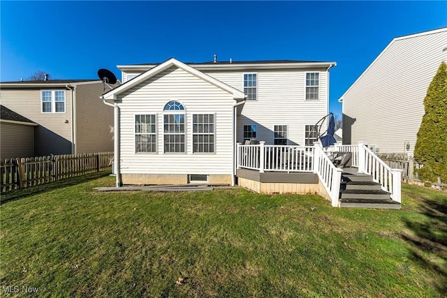 rear view of property featuring a wooden deck and a lawn