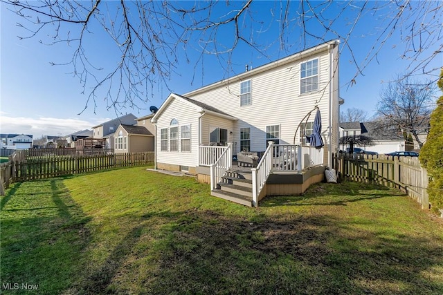 rear view of house with a wooden deck and a yard